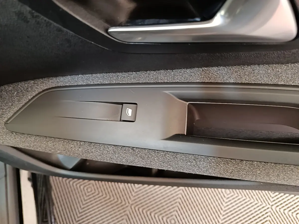 Gros plan sur la poignée intérieure et la commande de lève-vitre côté gauche d’un Peugeot 3008 noir de 2018.