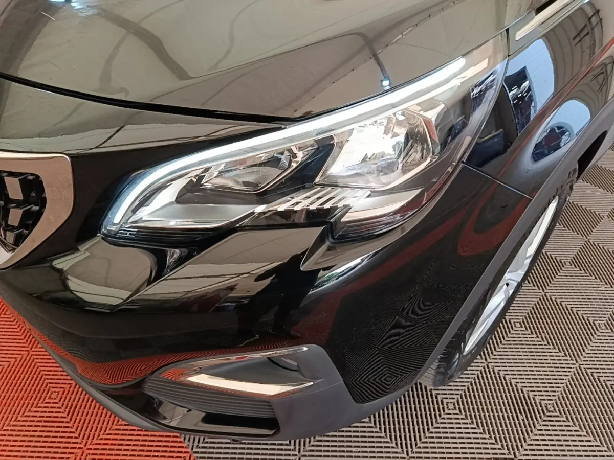 Gros plan sur l'avant droit noir brillant du Peugeot 3008 avec phare LED et calandre partielle visible.