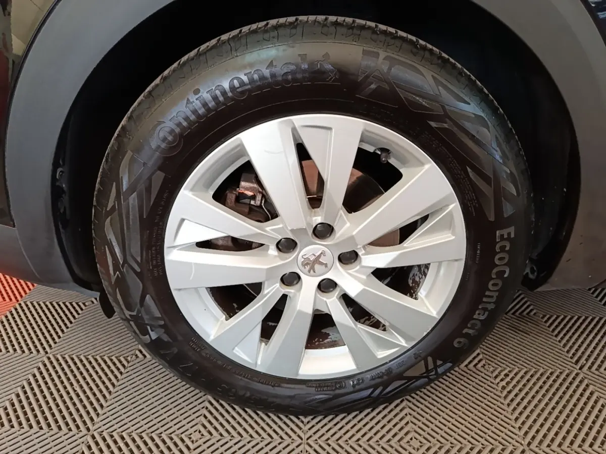 Gros plan sur la roue avant droite d’un Peugeot 3008 noir, avec jante alliage argentée et pneu Continental.