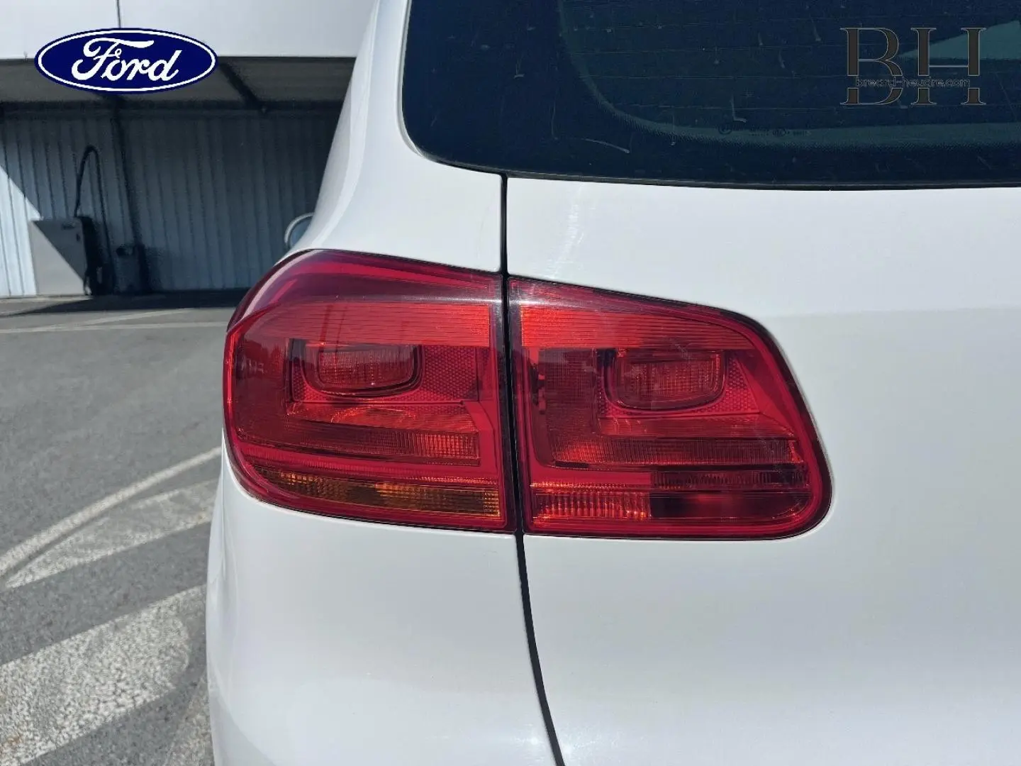 Gros plan sur le feu arrière gauche d’un Volkswagen Tiguan blanc Candy, vue arrière côté gauche.