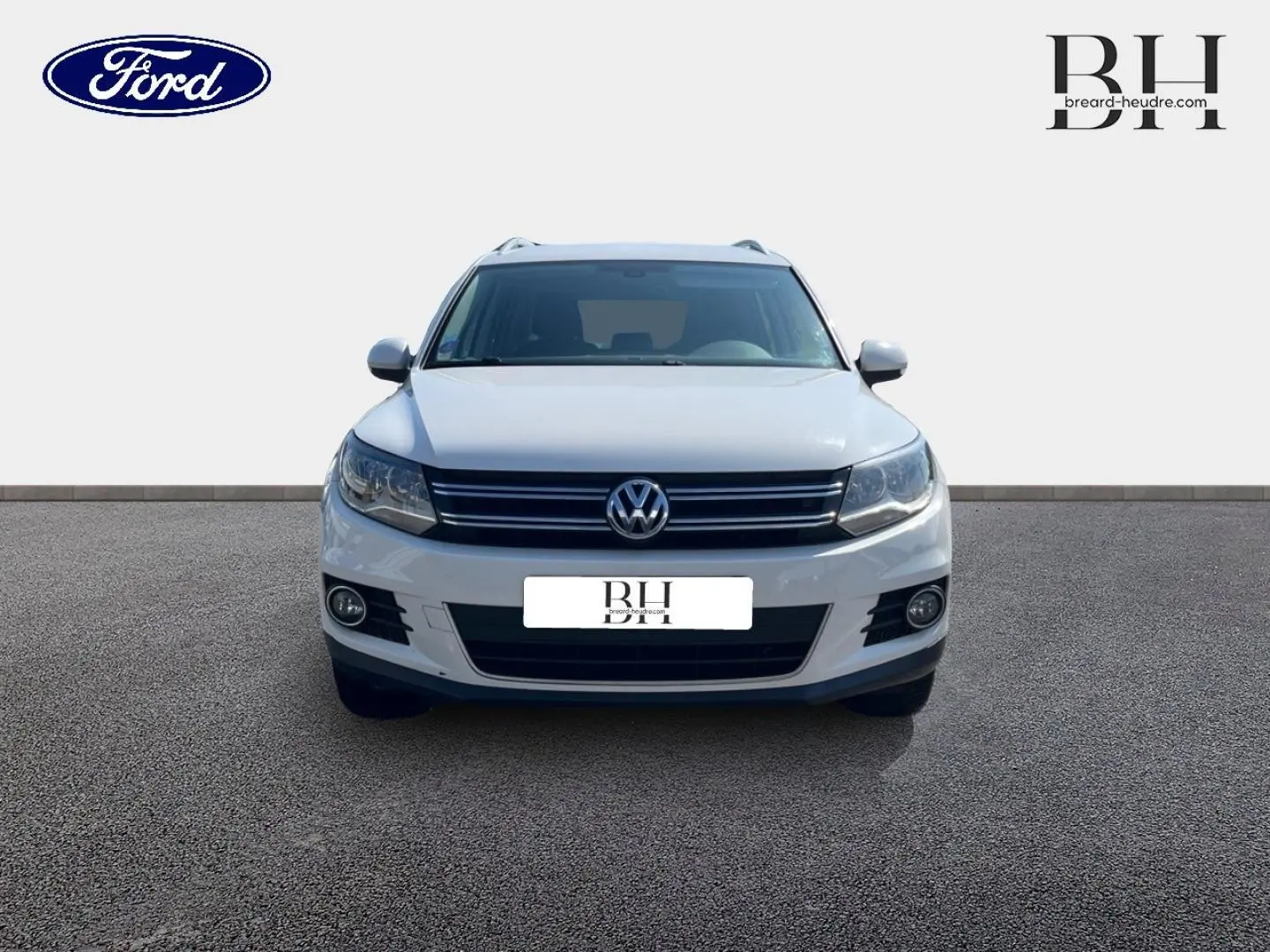 Vue de face du Volkswagen Tiguan blanc Candy 2013 avec calandre chromée et phares halogènes.