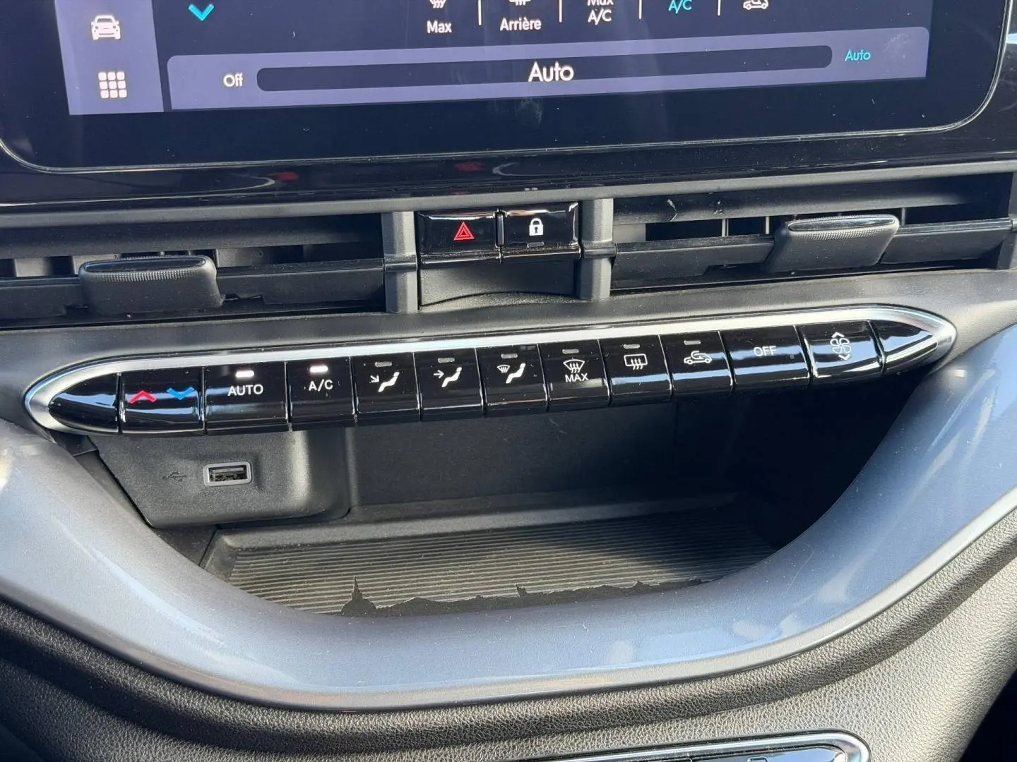 Gros plan sur la console centrale de la Fiat 500 e 118ch MY24 Onyx Black, montrant les commandes climatisation et un port USB.