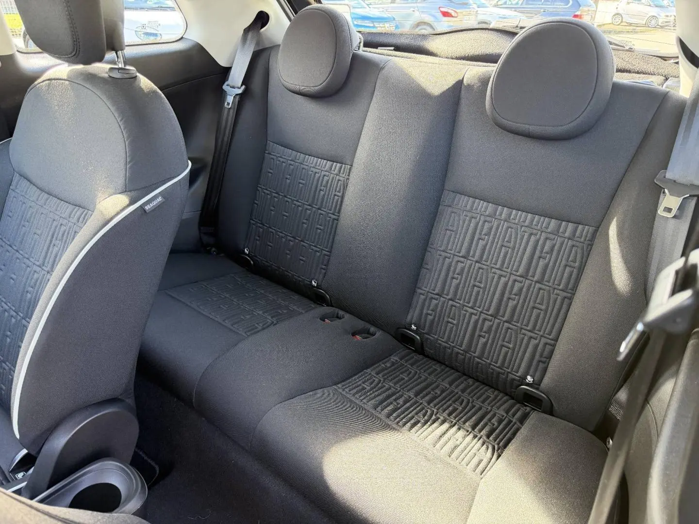 Vue intérieure arrière de la banquette noire monogrammée Fiat de la FIAT 500 e 118ch MY24 Onyx Black pastel.