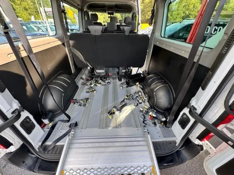 Vue arrière intérieure du Renault Master Combi blanc minéral aménagé TPMR avec fixation au sol et rampe d'accès.
