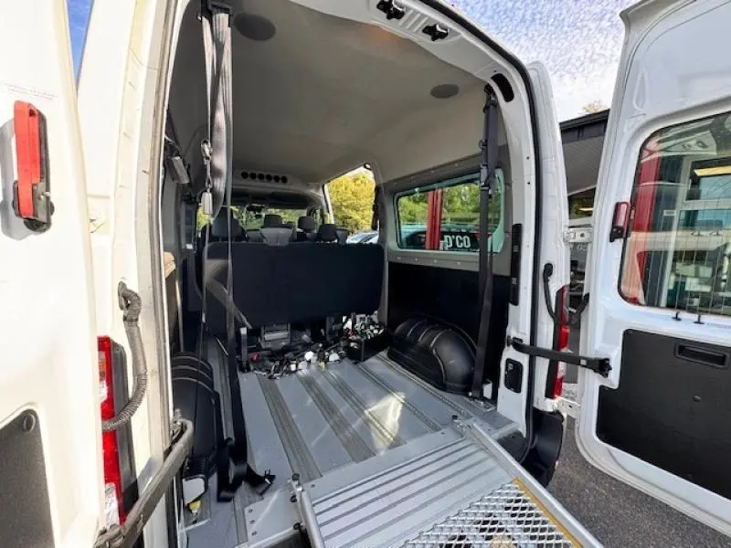 Vue arrière ouverte du Renault Master Combi blanc minéral, montrant l'aménagement TPMR avec rampe d'accès et sièges arrière.