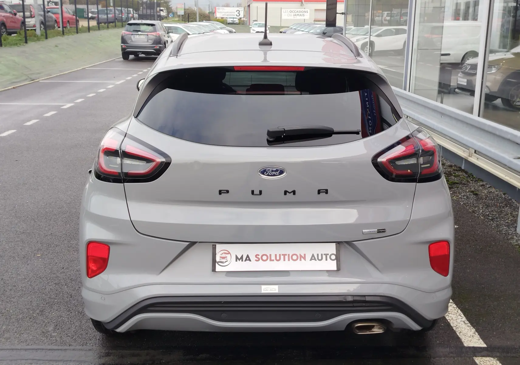 Vue arrière d'une Ford Puma 1.0 EcoBoost gris Fashion avec feux LED et lunette arrière teintée.