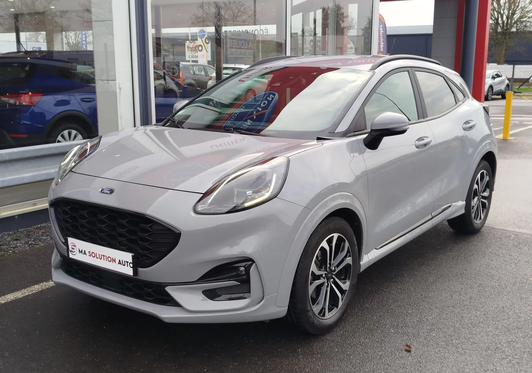 Ford Puma 1.0 EcoBoost gris Fashion en vue 3/4 avant droit, avec jantes bi-ton et calandre noire distinctive.