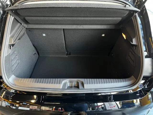 Coffre ouvert vu de l'arrière d'une Renault Clio noire 2025, montrant l'espace de chargement et la tablette arrière.