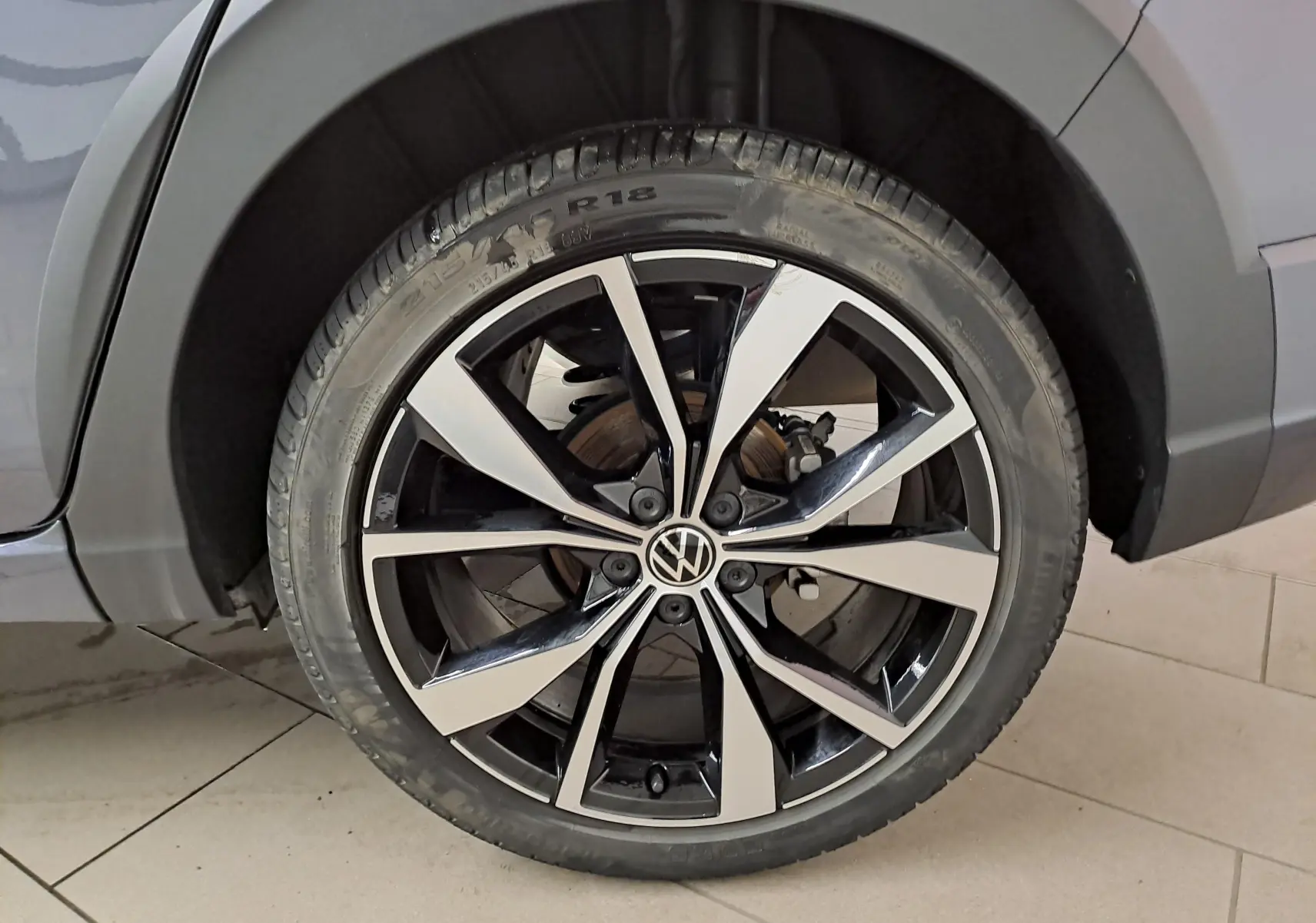 Gros plan sur la jante alliage 18 pouces "Misano" bicolore du Volkswagen Taigo gris cendré, côté arrière droit.