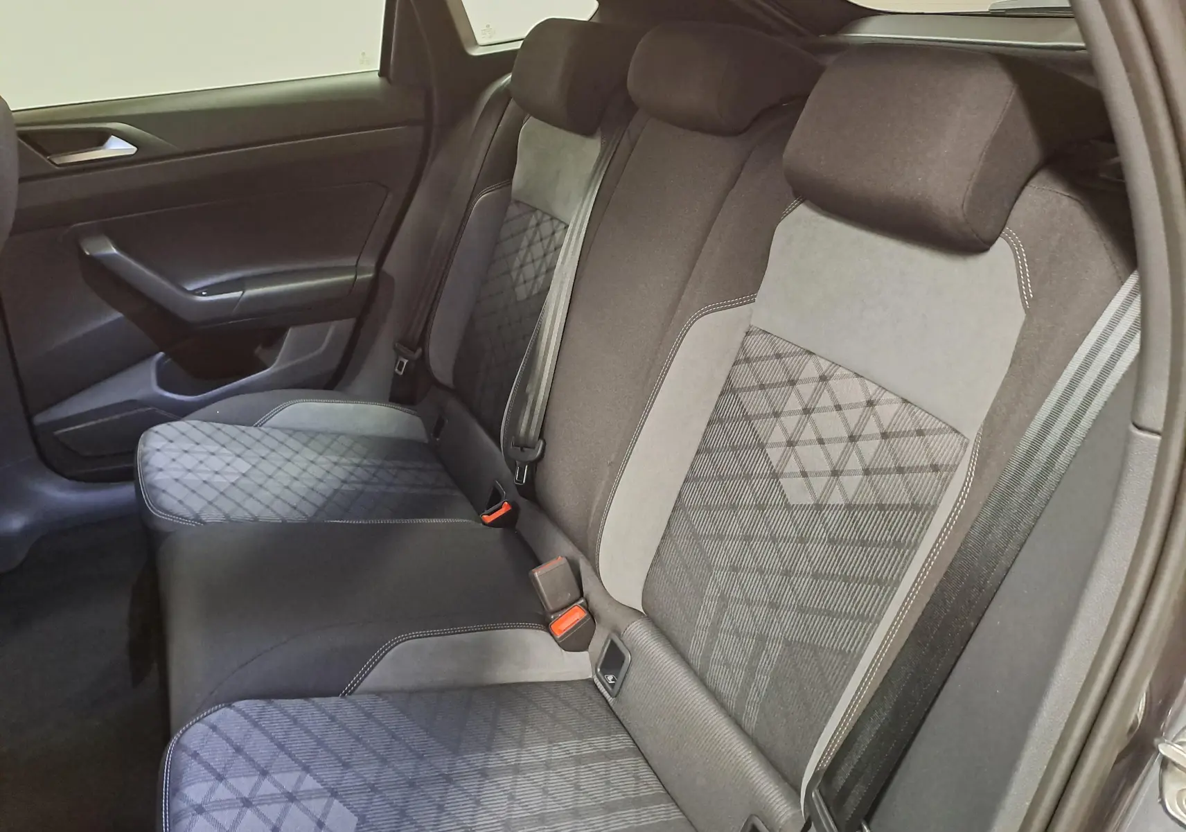 Vue intérieure montrant la banquette arrière en tissu gris et noir du Volkswagen Taigo 1.5 TSI 150 DSG7 R-Line Edition.