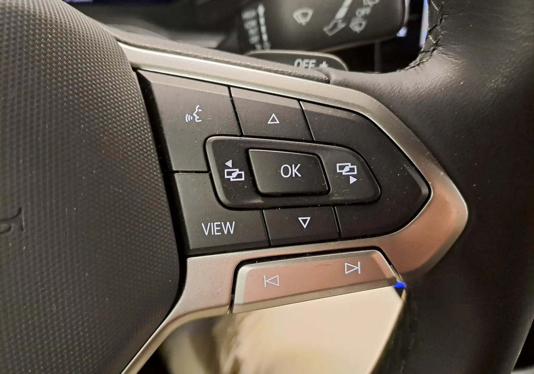 Gros plan sur les commandes multifonctions au volant du Volkswagen Taigo gris cendré, version R-Line Edition 2025.