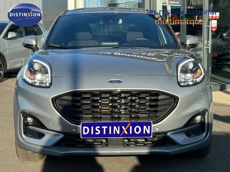 Vue frontale d'un Ford Puma 1.0 EcoBoost 155ch mHEV ST-Line gris Solar métallisé avec calandre noire et phares LED.