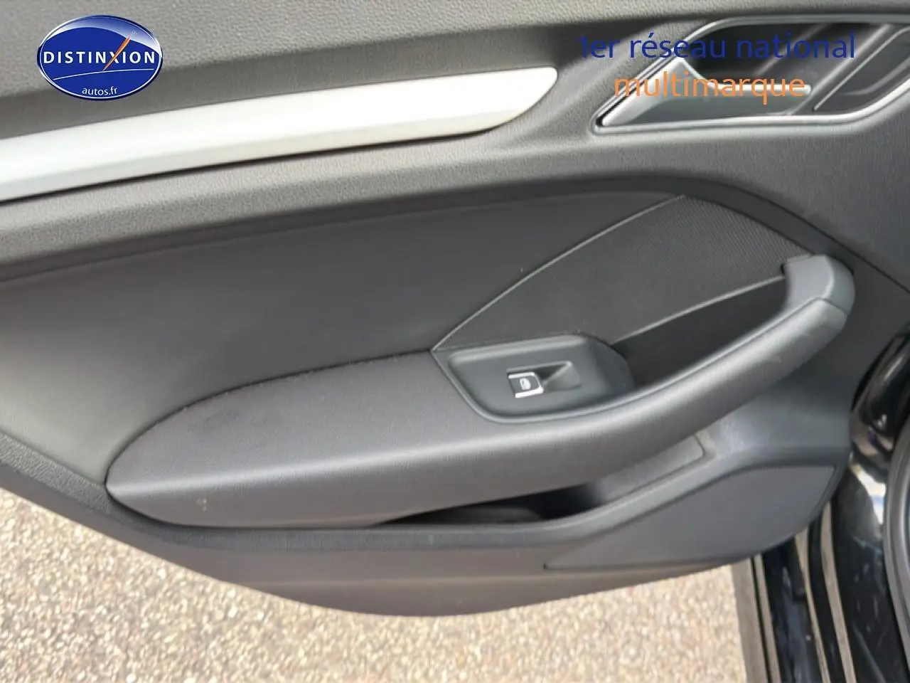 Vue rapprochée de la porte côté gauche noire de l'Audi A3 Sportback avec poignée et bouton de verrouillage électrique.