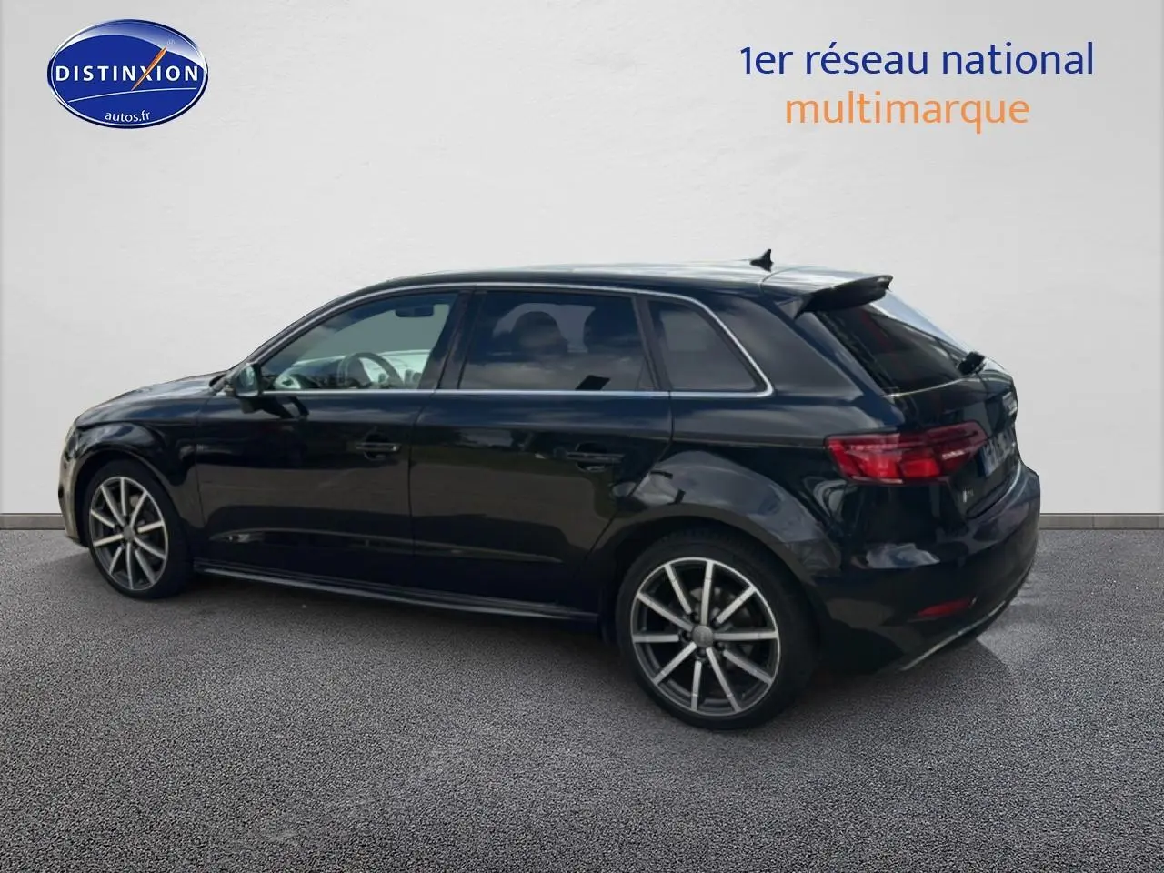 Audi A3 Sportback noir vue de profil côté gauche, jantes alliage et becquet arrière visibles.