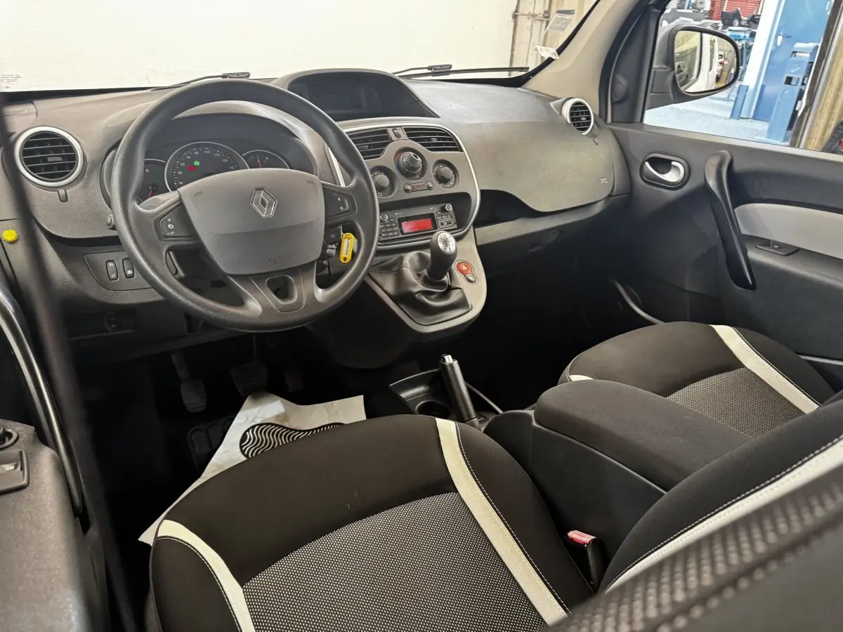 Vue intérieure avant droite du Renault Kangoo 2016 Zen Energy dCi, tableau de bord noir avec volant multifonctions et sièges tissu bicolore.