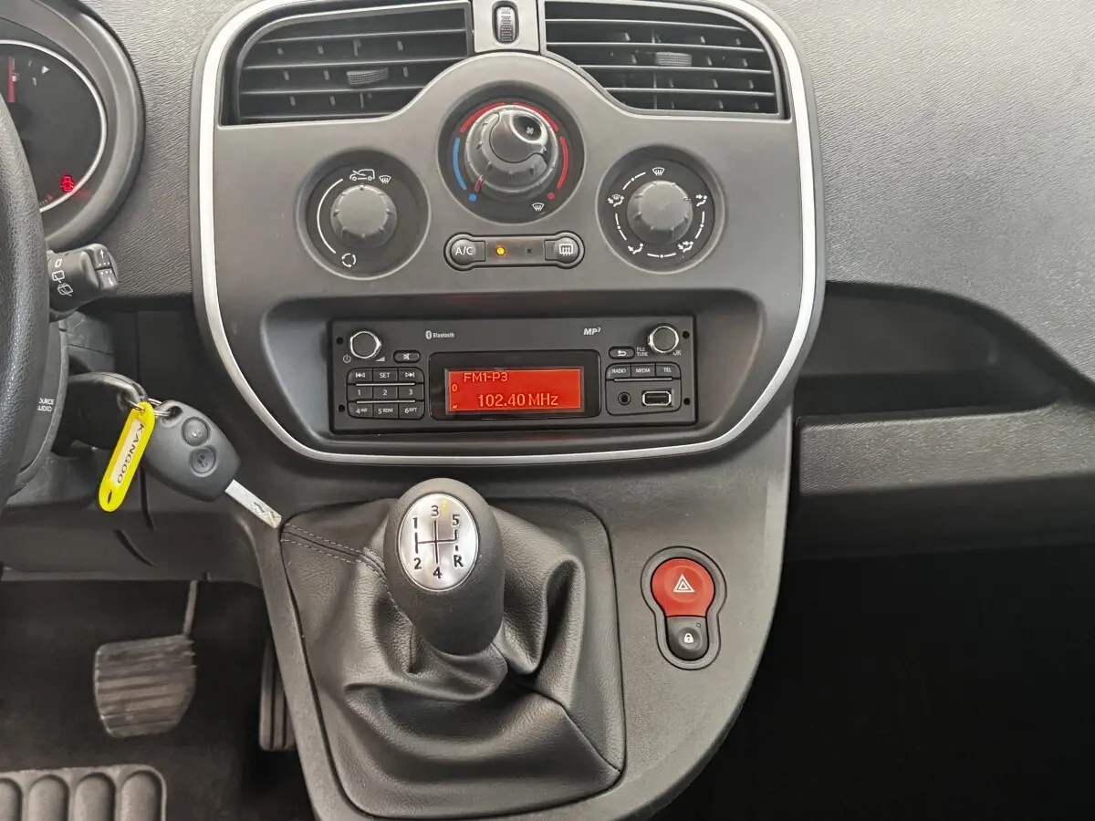 Vue rapprochée de la console centrale du Renault Kangoo Zen 2016 avec levier de vitesse manuel et radio allumée.