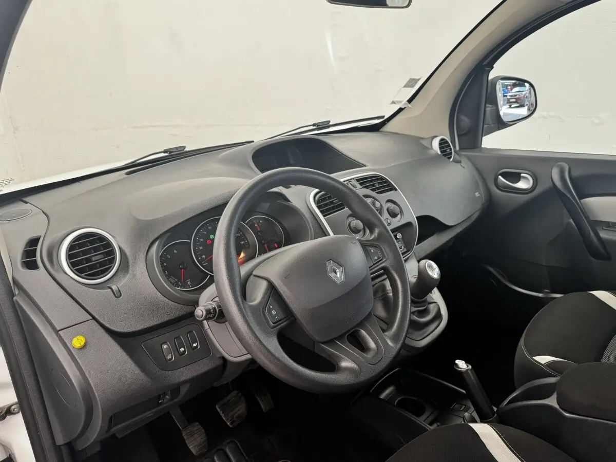 Vue intérieure côté conducteur du tableau de bord et volant multifonctions d’un Renault Kangoo blanc de 2016.