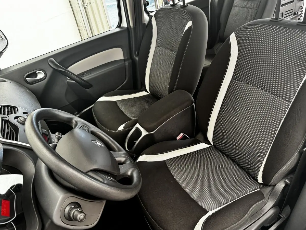 Vue intérieure avant droite du Renault Kangoo 2016, sièges noirs avec bandes blanches et volant multifonctions.