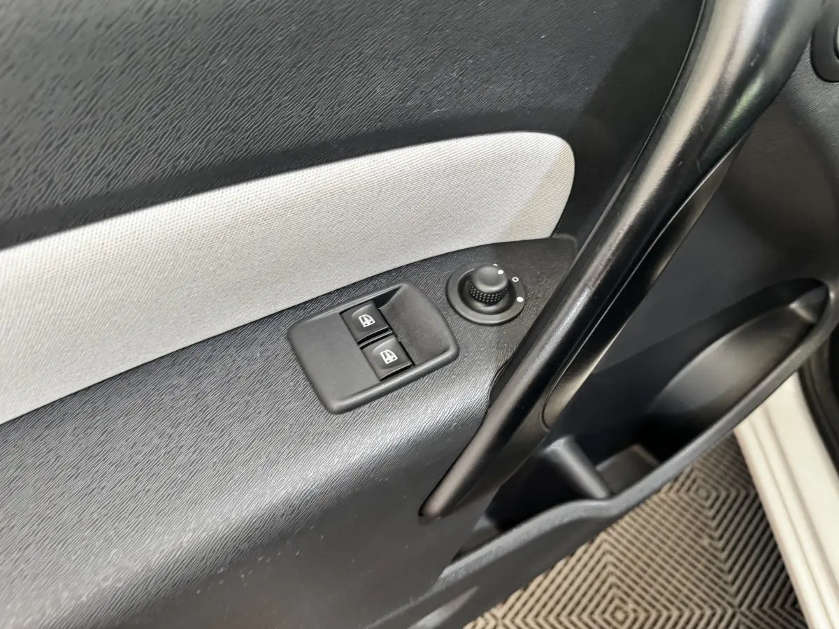 Détail de la porte côté conducteur du Renault Kangoo blanc 2016, avec commandes électriques des vitres et réglage des rétroviseurs.