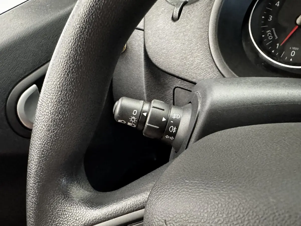 Gros plan sur le commodo d’éclairage à gauche du volant noir dans l’habitacle du Renault Kangoo blanc 2016.