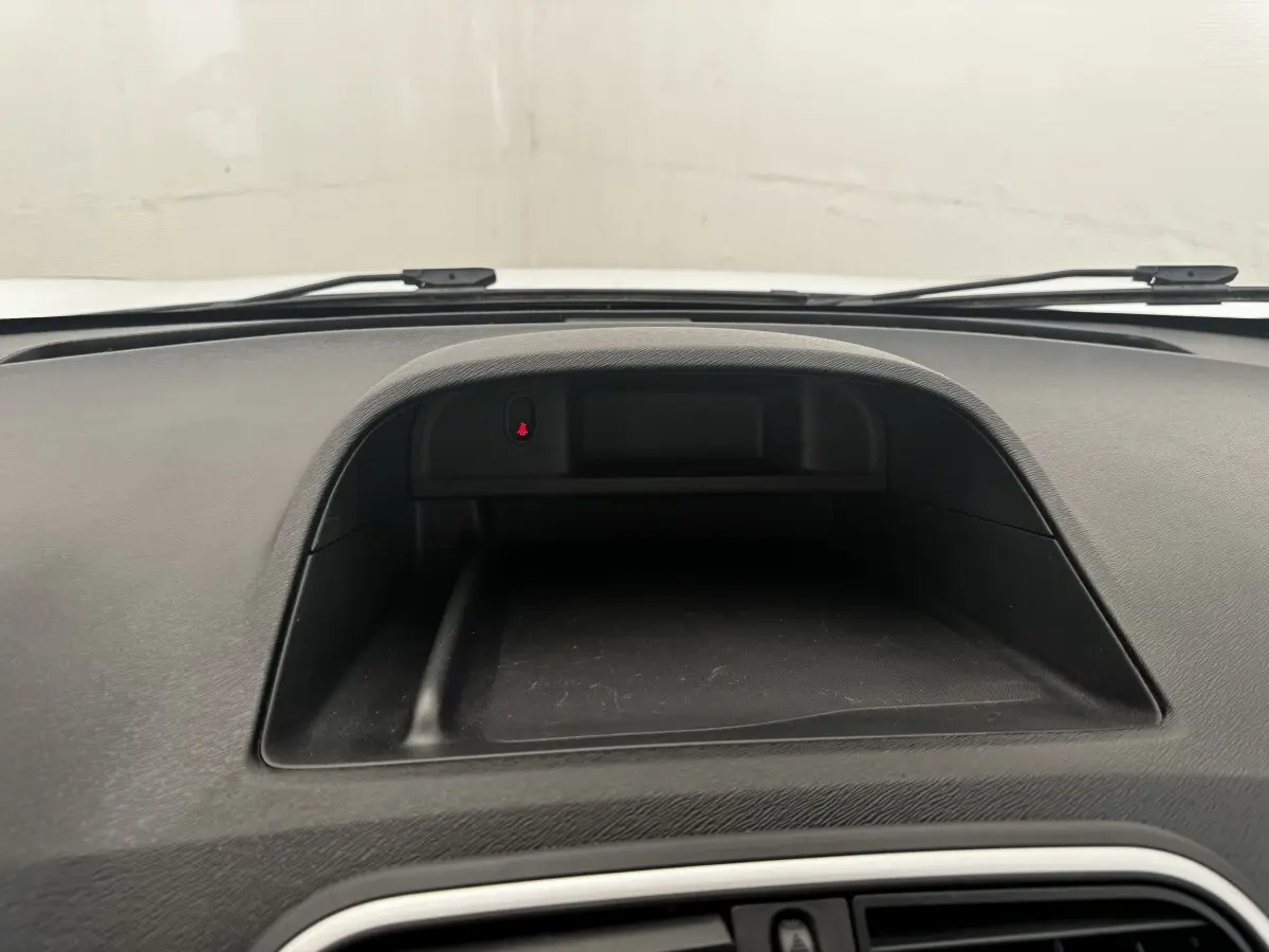 Vue rapprochée du tableau de bord noir du Renault Kangoo blanc 2016, avec espace de rangement intégré.