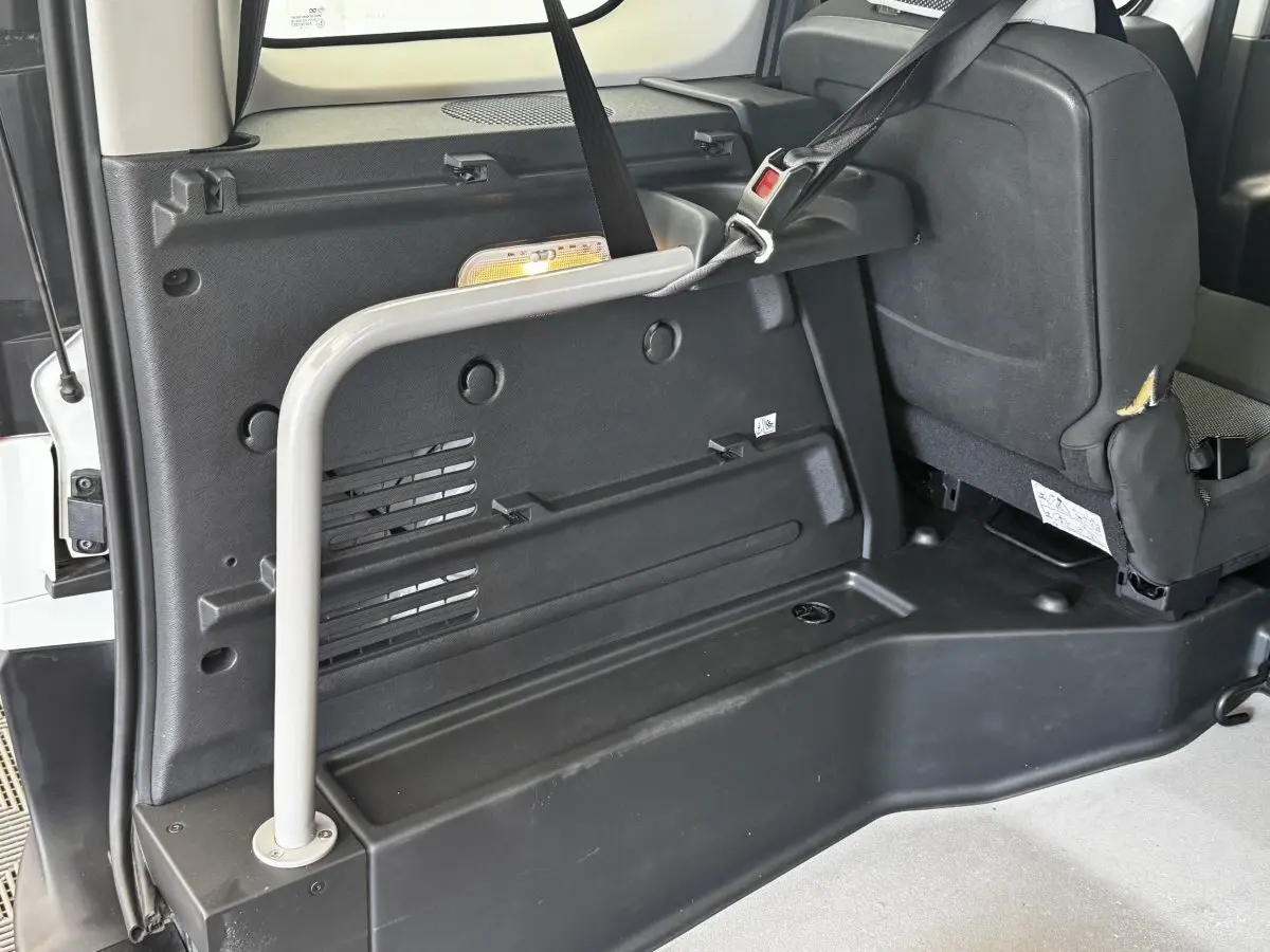 Vue intérieure arrière droite du Renault Kangoo blanc 2016, montrant la banquette et les fixations Isofix.