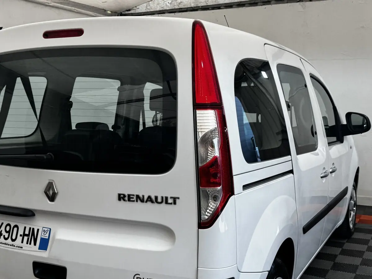 Vue 3/4 arrière droite d'un Renault Kangoo blanc 2016 avec feux arrière verticaux et vitres teintées.