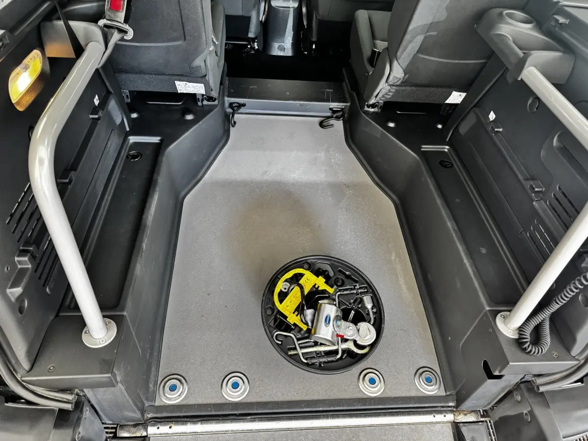 Vue intérieure du coffre du Renault Kangoo Zen blanc 2016, montrant le plancher plat avec outils rangés au centre.