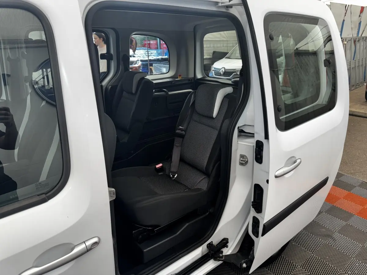 Vue latérale droite du Renault Kangoo blanc 2016 avec porte coulissante ouverte et siège arrière visible.