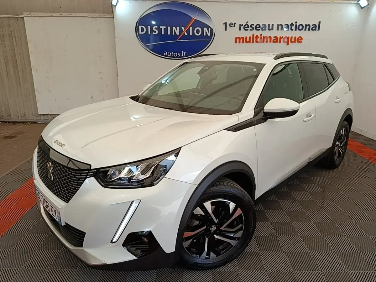 Peugeot 2008 blanc en 3/4 avant droit, avec jantes noires et toit noir dans un showroom intérieur.