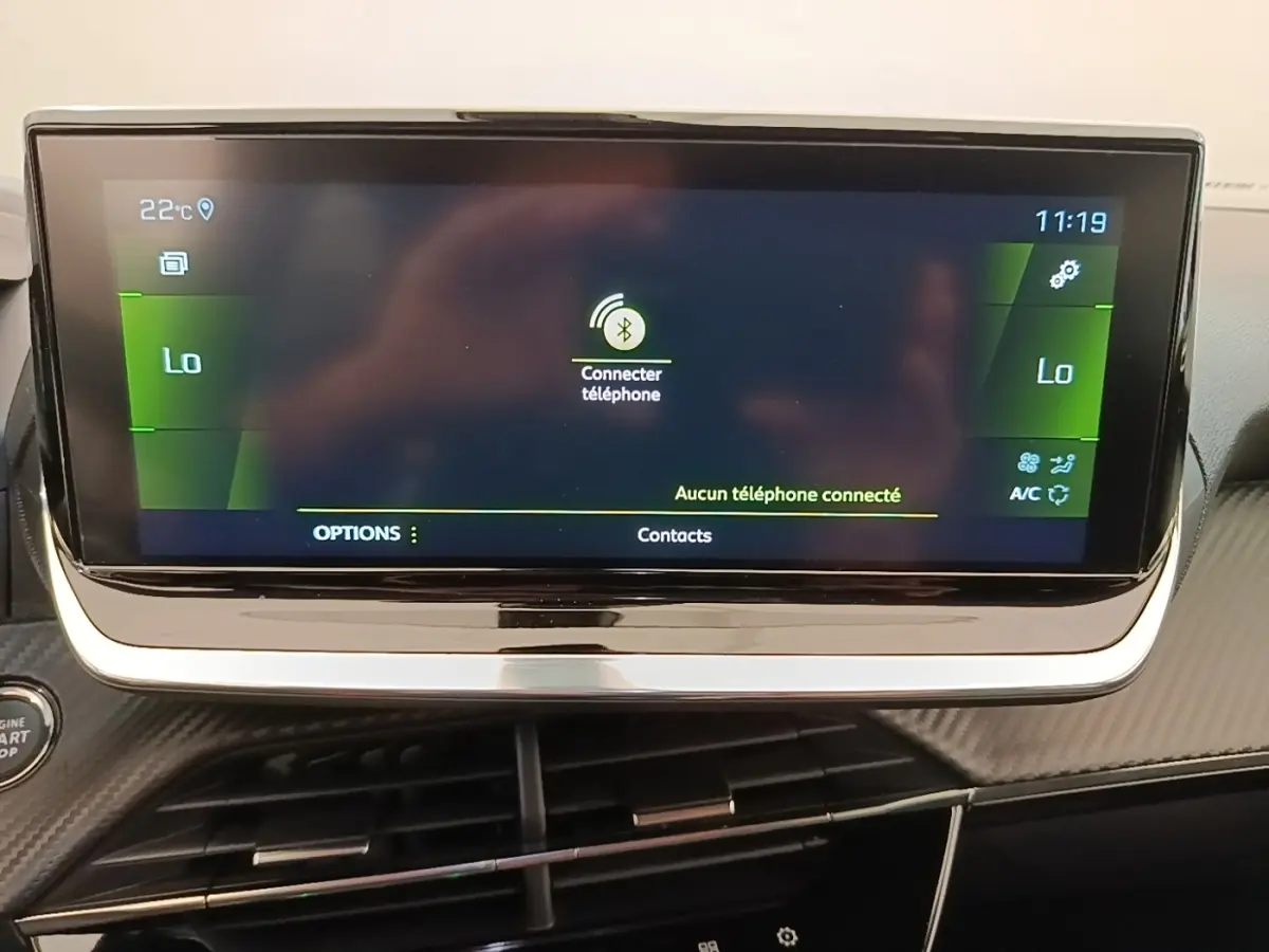 Écran tactile central du tableau de bord de la Peugeot 2008 blanc, affichant la connexion Bluetooth au téléphone.