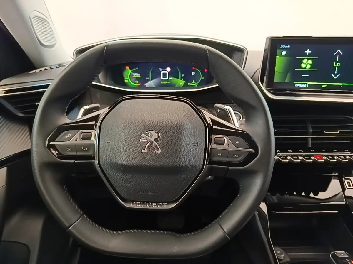 Vue rapprochée du volant cuir multifonctions noir du Peugeot 2008 avec tableau de bord numérique et écran tactile central.