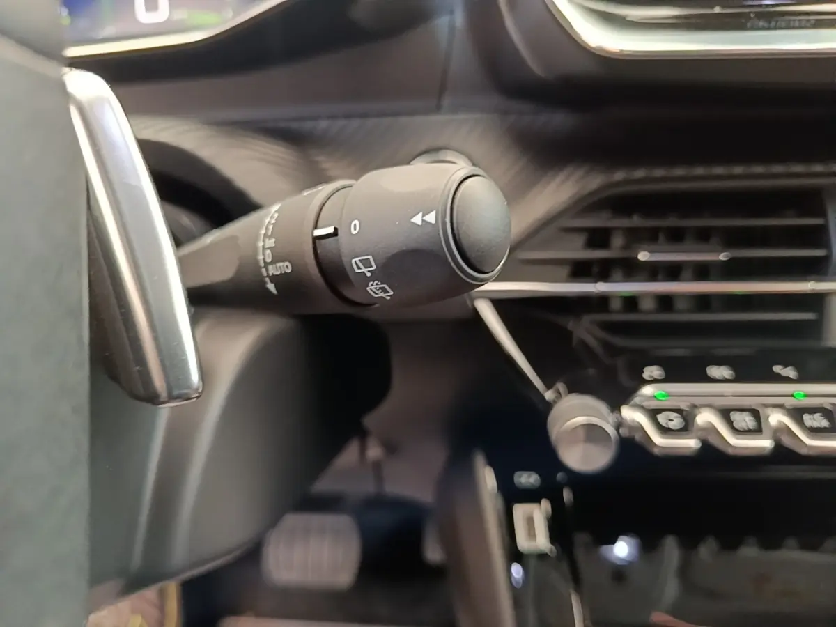 Gros plan sur la commande des essuie-glaces dans l’habitacle noir du Peugeot 2008 diesel blanc, version 2021.