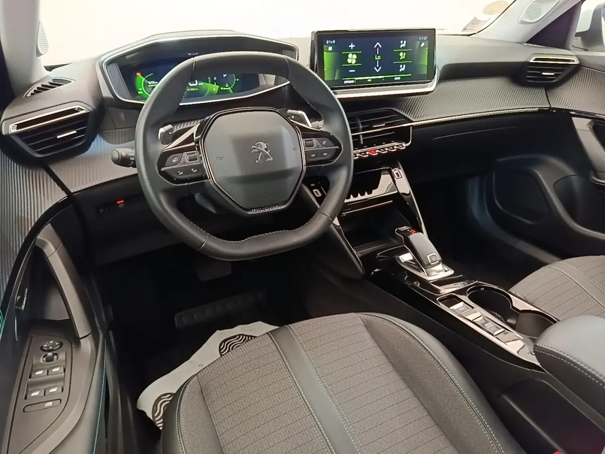 Intérieur avant du Peugeot 2008 blanc 2021, vue du poste de conduite avec volant cuir et écran tactile central.