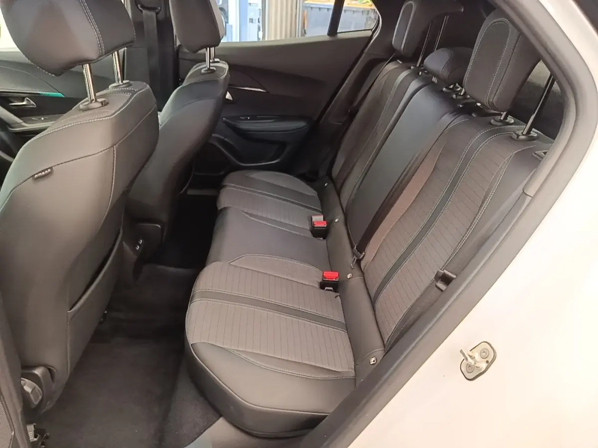 Vue intérieure côté droit sur la banquette arrière en tissu noir du Peugeot 2008 blanc, avec appuie-têtes et ceintures visibles.
