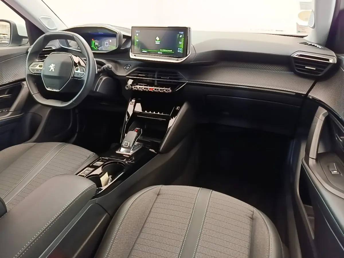 Intérieur noir et gris du Peugeot 2008 2021, vue de face côté conducteur avec volant cuir et écran tactile central.