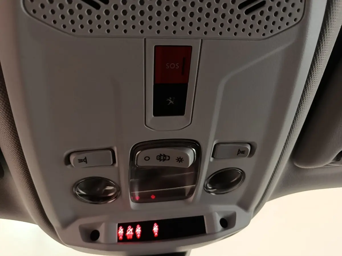 Vue en gros plan du plafonnier intérieur gris clair avec boutons de lumière et alerte SOS du Peugeot 2008 blanc de 2021.