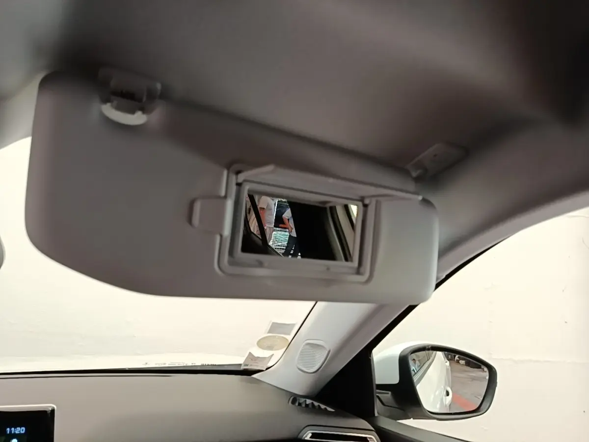 Intérieur du Peugeot 2008 blanc, vue côté droit sur le pare-soleil avec miroir de courtoisie ouvert.