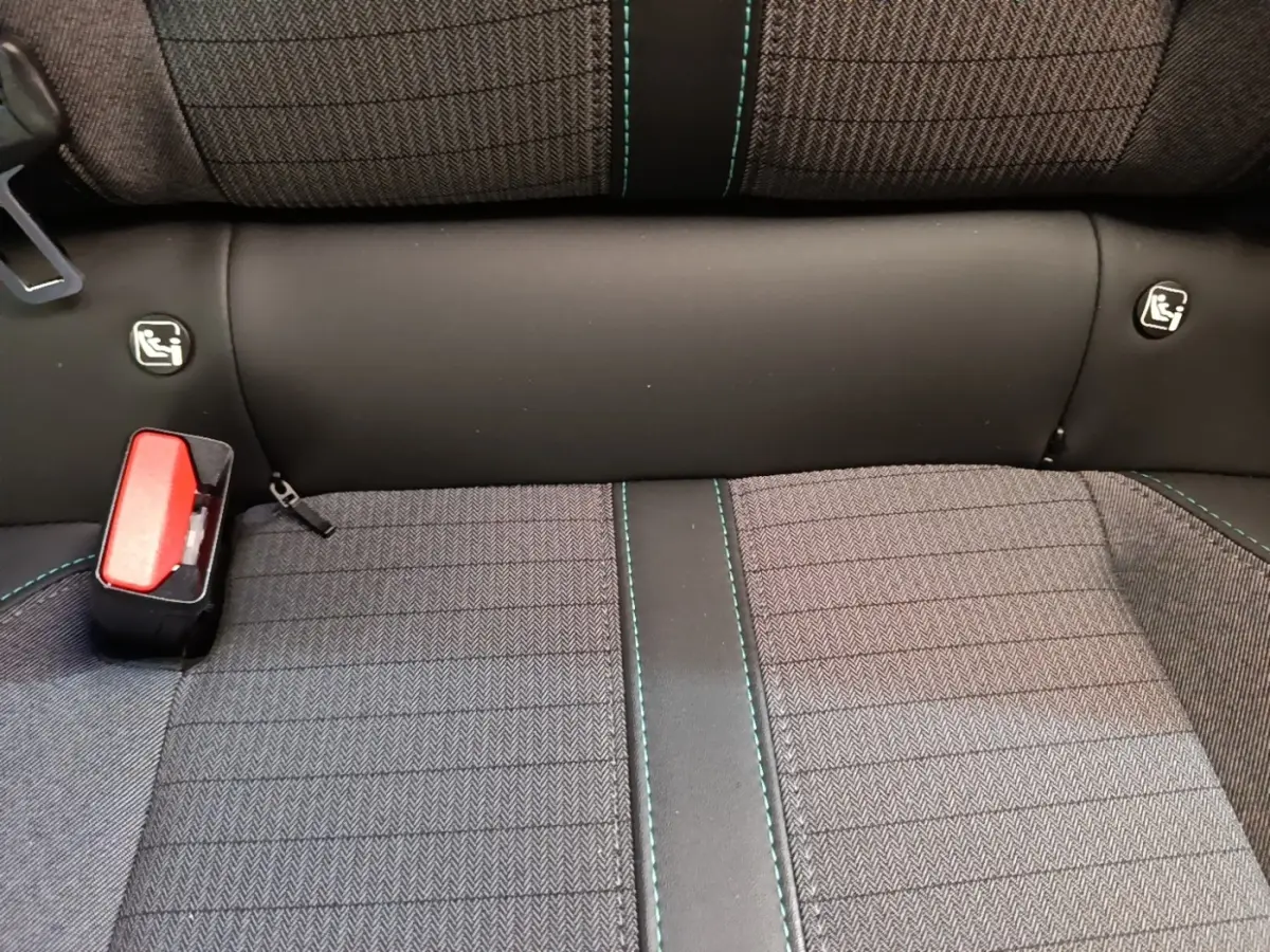 Détail de la banquette arrière grise avec surpiqûres vertes et attaches Isofix du Peugeot 2008 blanc.