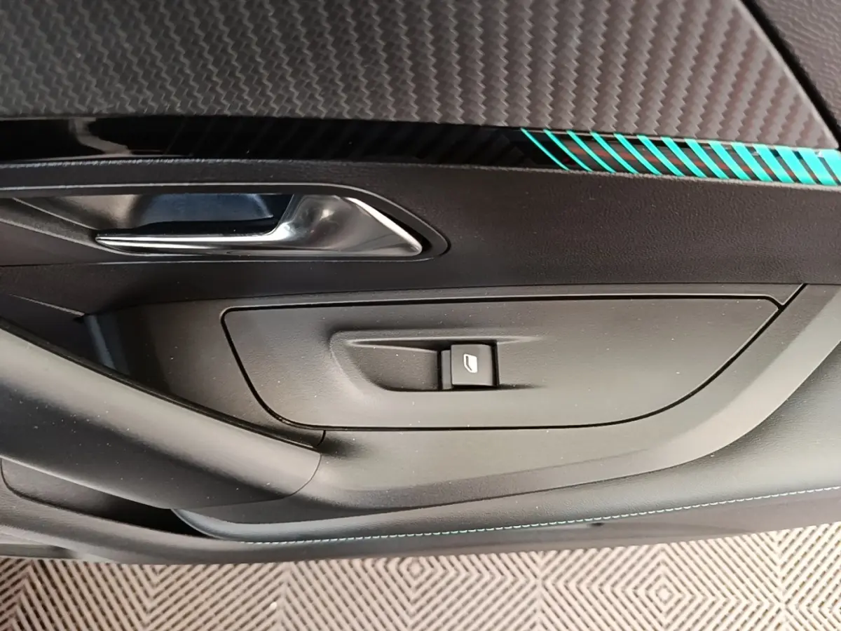 Détail de la porte intérieure côté conducteur du Peugeot 2008 blanc, avec poignée argentée et bouton de vitre électrique.