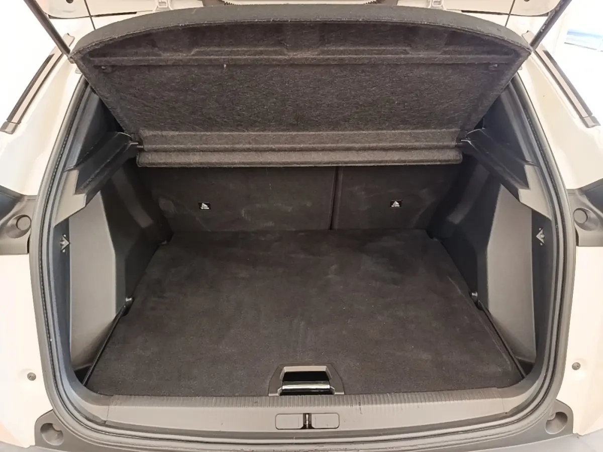 Coffre ouvert vu de l’arrière d’un Peugeot 2008 blanc, montrant un espace de chargement propre et spacieux.