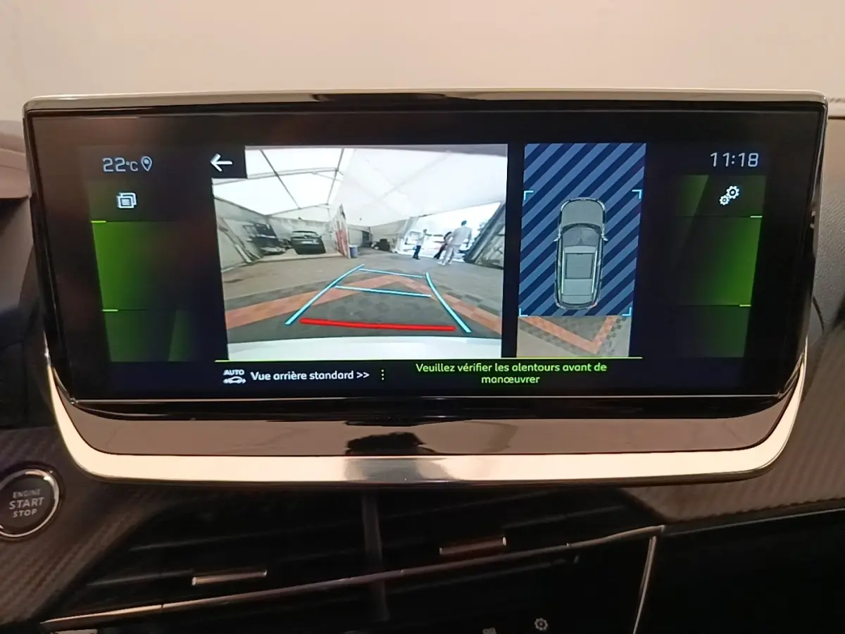 Écran tactile intérieur du Peugeot 2008 blanc montrant la caméra de recul et l'aide au stationnement en vue arrière.