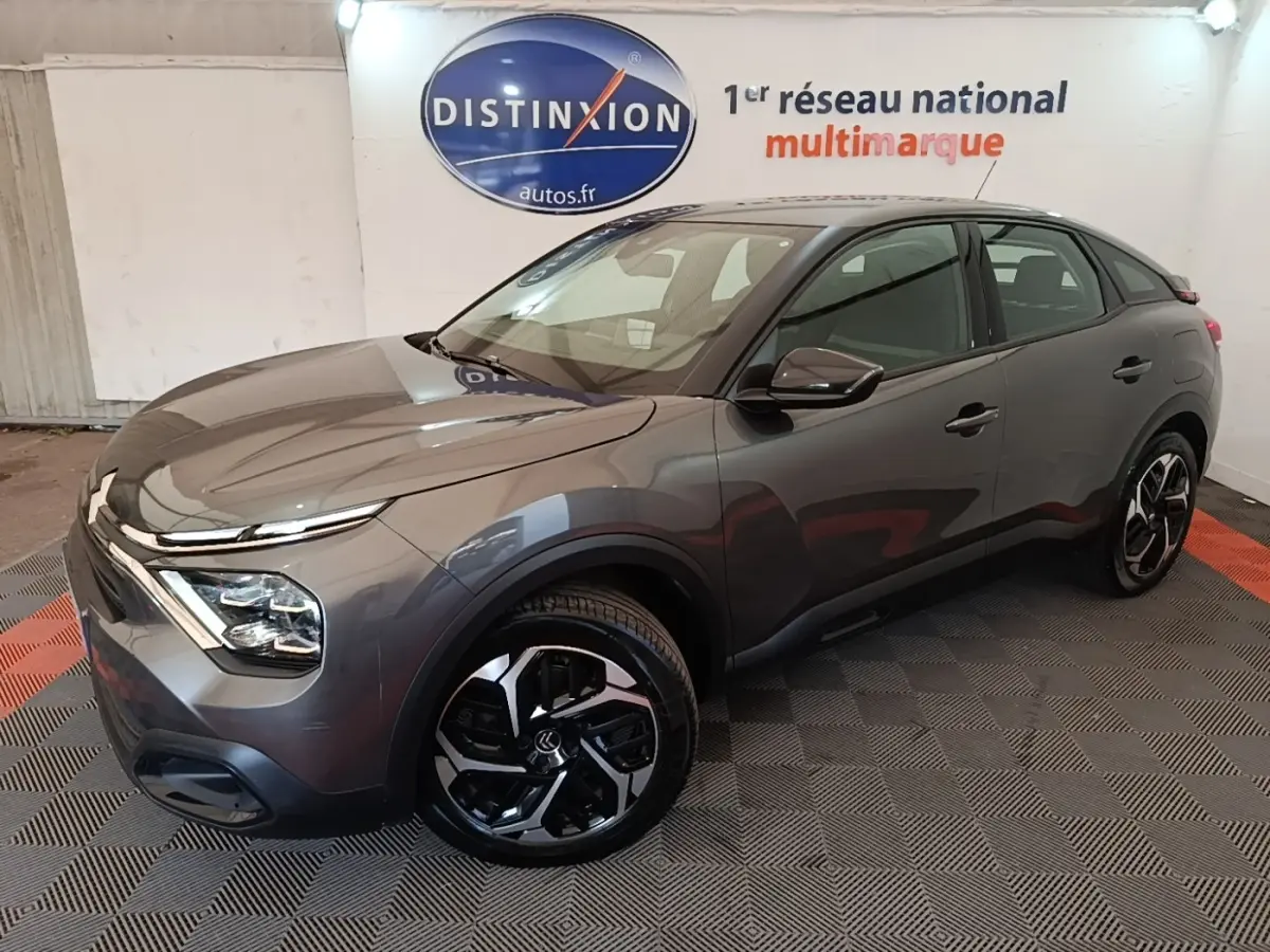 Citroën C4 gris clair vue 3/4 avant droit, avec jantes noires et design moderne des phares LED.