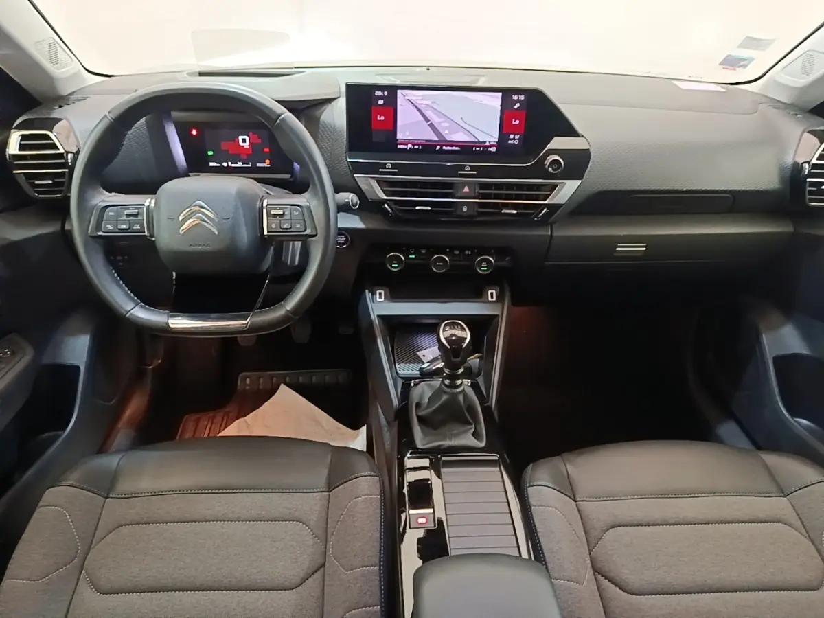 Vue intérieure avant de la Citroën C4 2021, tableau de bord noir avec écran tactile 10 pouces et volant cuir multifonctions.