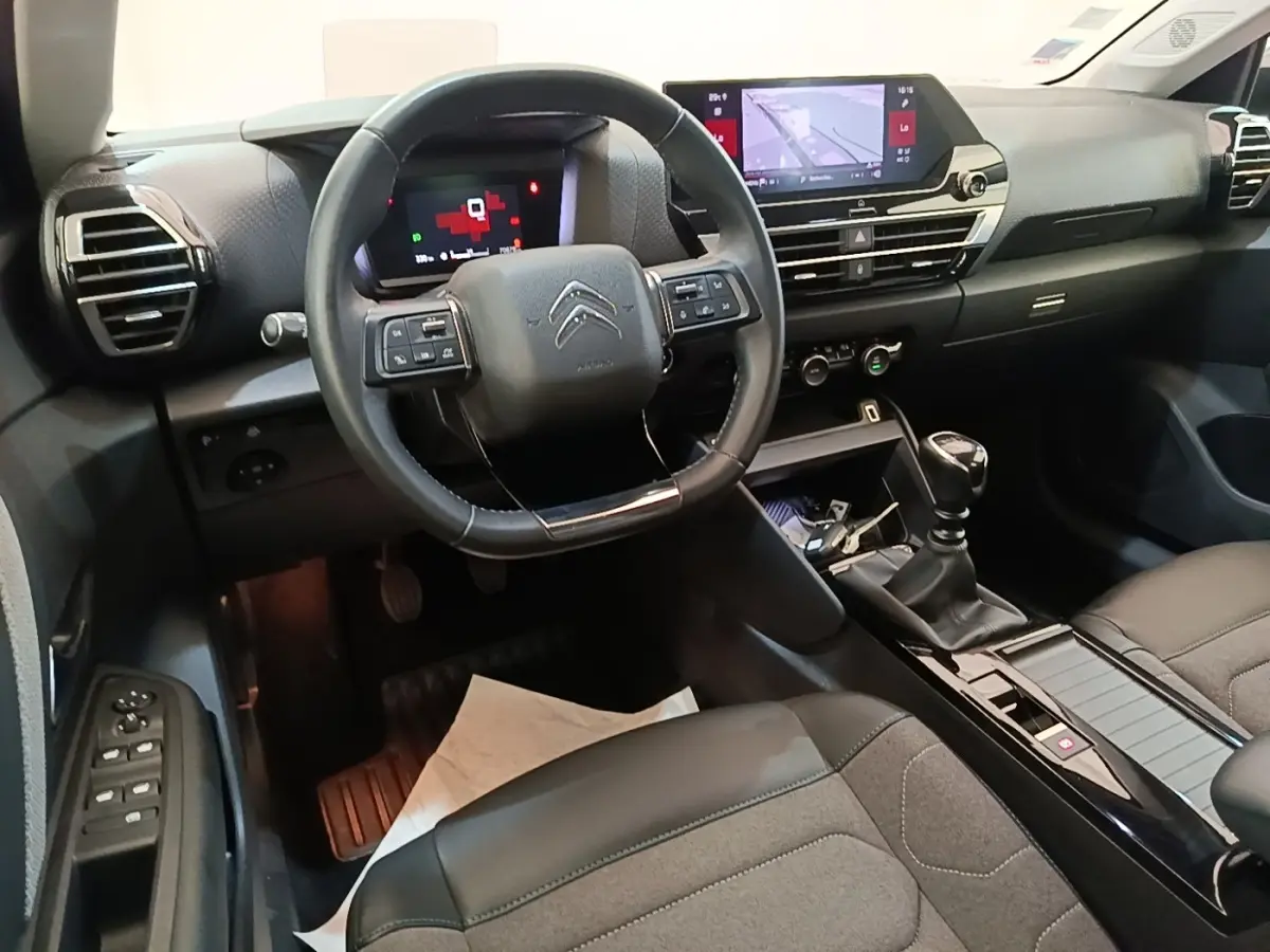 Vue intérieure de face du poste de conduite de la Citroën C4 2021 avec volant cuir et écran tactile central.