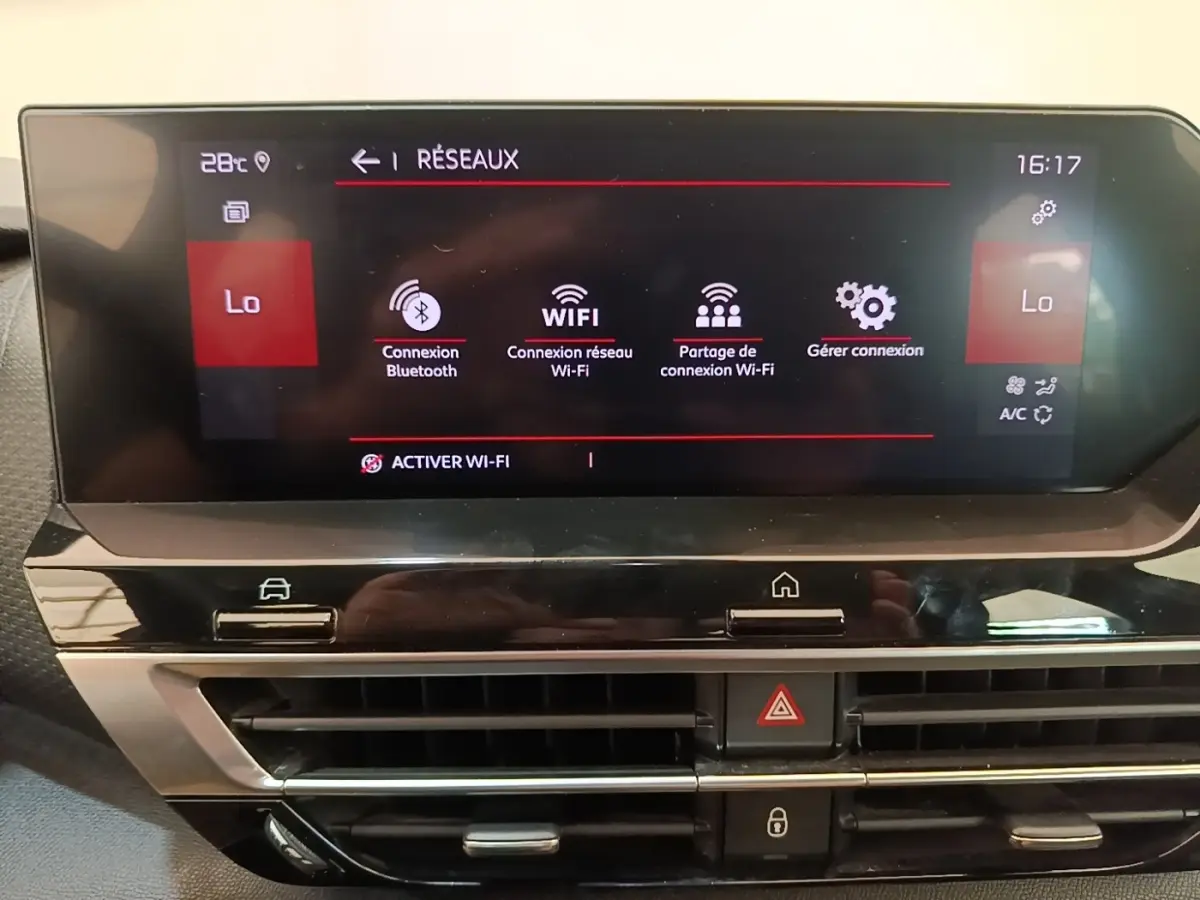 Gros plan sur l’écran tactile central du tableau de bord de la Citroën C4 gris clair, affichant les options Wi-Fi et Bluetooth.