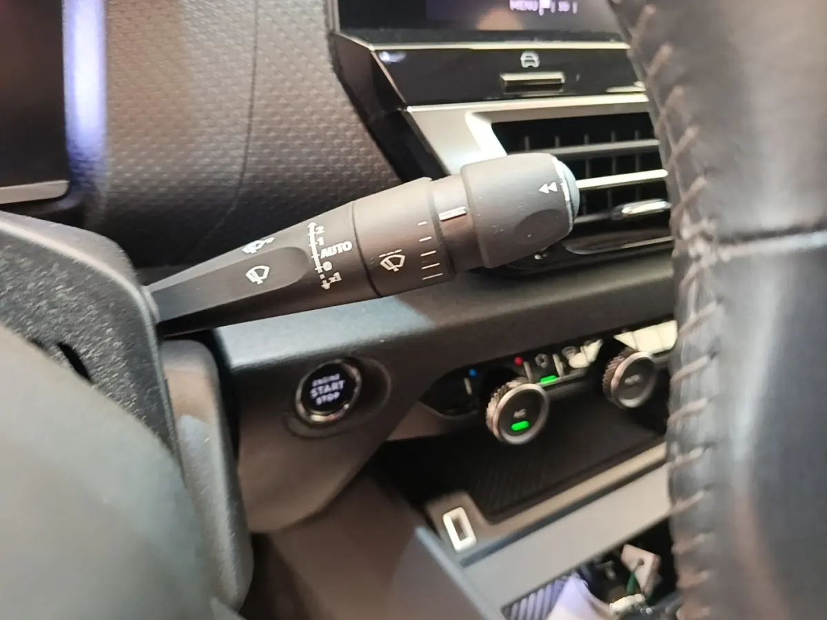 Gros plan sur la commande d’essuie-glace et le bouton start/stop côté gauche du tableau de bord d’une Citroën C4 gris clair.