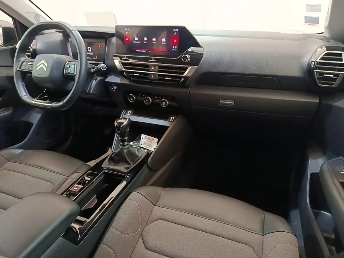 Intérieur de Citroën C4 gris clair, vue côté conducteur, volant cuir multifonctions et écran tactile central.