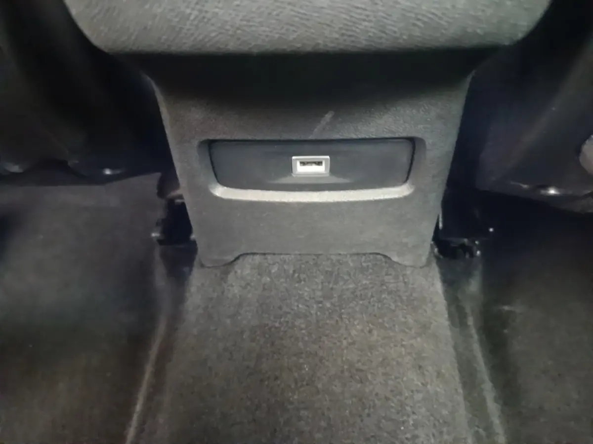 Prise USB arrière centrale dans l’habitacle noir d’une Citroën C4 PureTech 130 essence 2021.