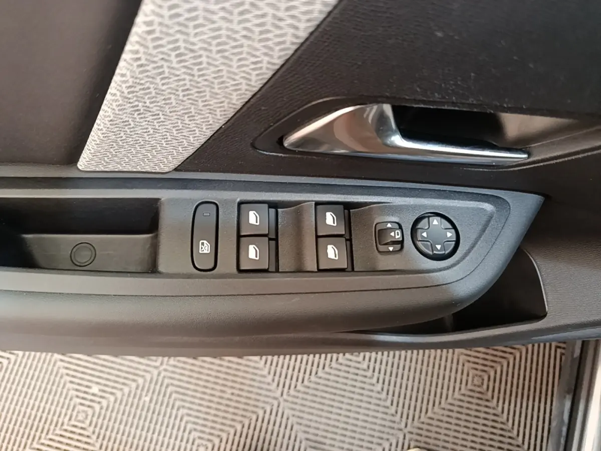 Vue rapprochée de la porte côté gauche de la Citroën C4 2021, avec commandes des vitres et rétroviseurs.